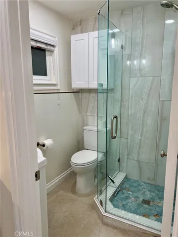 a bathroom with a toilet and a shower