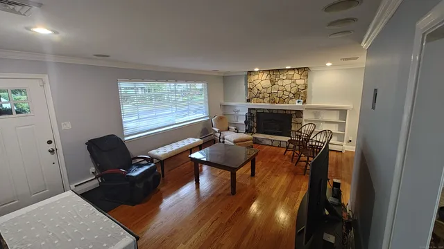 a living room with furniture floor to ceiling window and a flat screen tv
