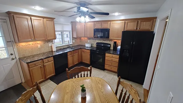 a kitchen with stainless steel appliances granite countertop a refrigerator a stove top oven a sink dishwasher and wooden cabinets