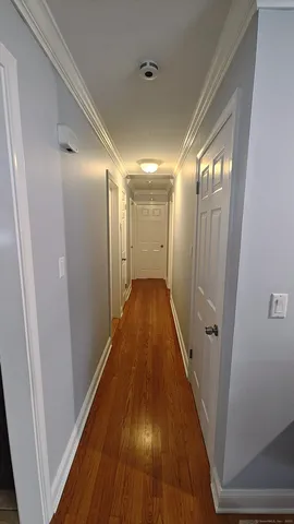 a view of a hallway with wooden floor and staircase