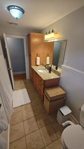 a bathroom with a toilet sink and mirror