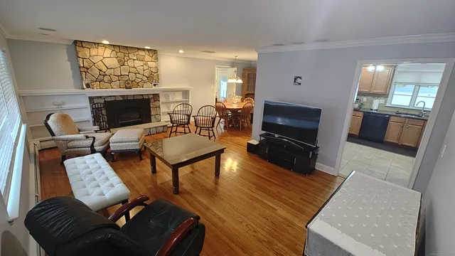 a living room with furniture a flat screen tv and a fireplace