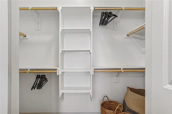 a view of walk in closet with empty racks