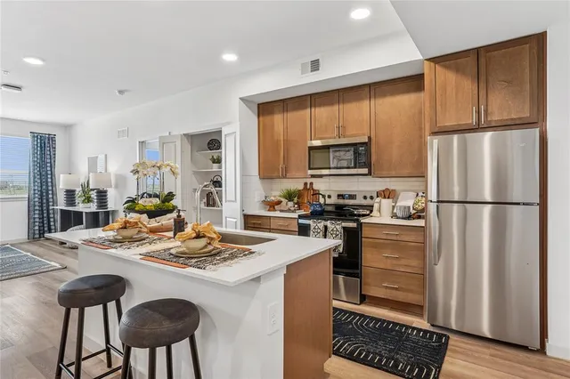 a kitchen with a refrigerator a stove a sink dishwasher with a dining table and chairs