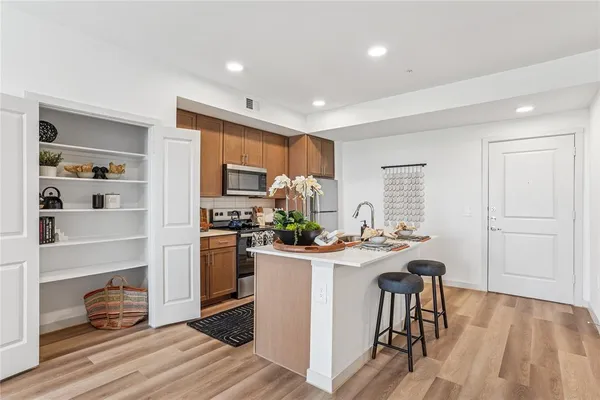 a kitchen with a table chairs refrigerator and microwave