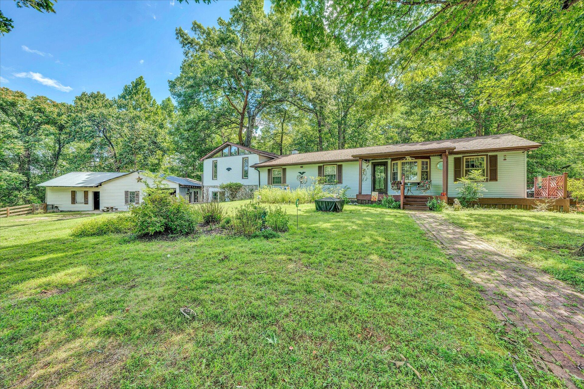 a front view of a house with a yard and trees