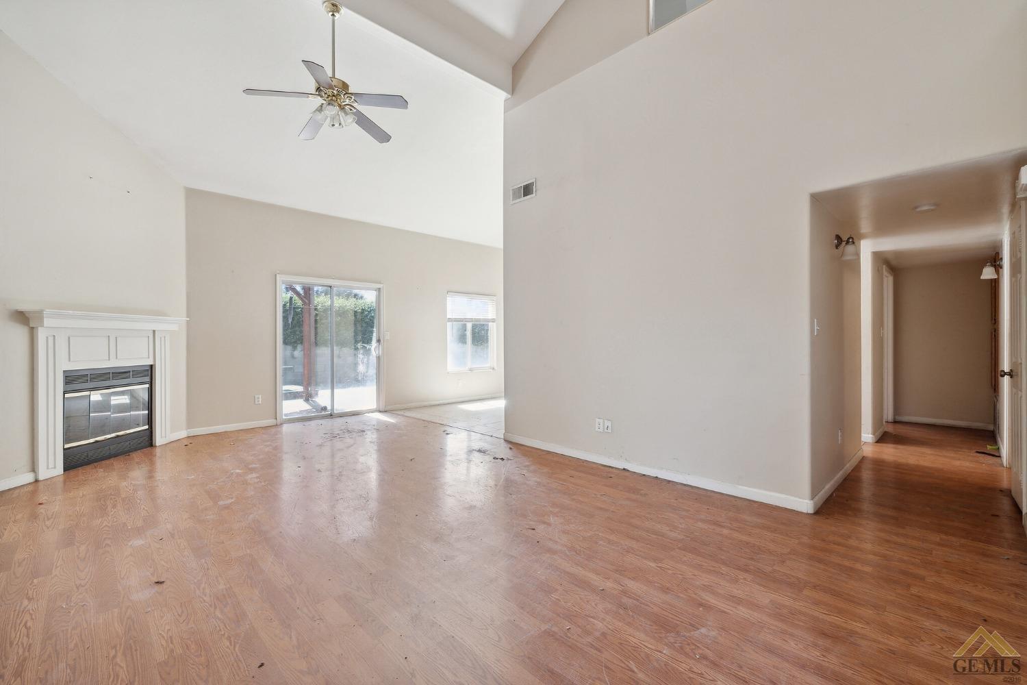 Undisclosed Address Bakersfield, CA 93307 - Photo 2 of 6 a view of a livingroom with wooden floor and a ceiling fan