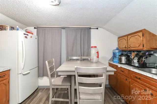 a kitchen with a refrigerator a stove a sink and chairs