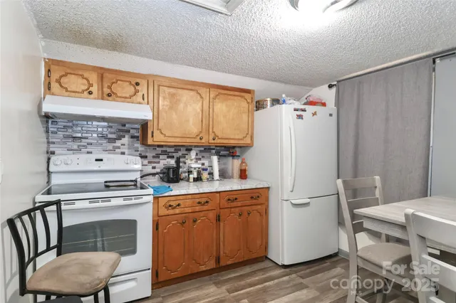 a kitchen with granite countertop a stove a sink and a wooden cabinets