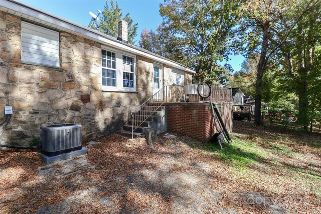 a view of a house with a yard chairs and tree