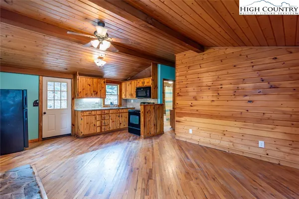a kitchen with stainless steel appliances wooden floors and wooden cabinets