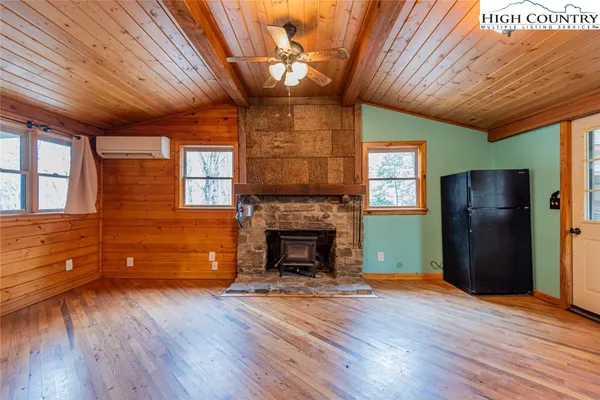a view of empty room with wooden floor and a fireplace