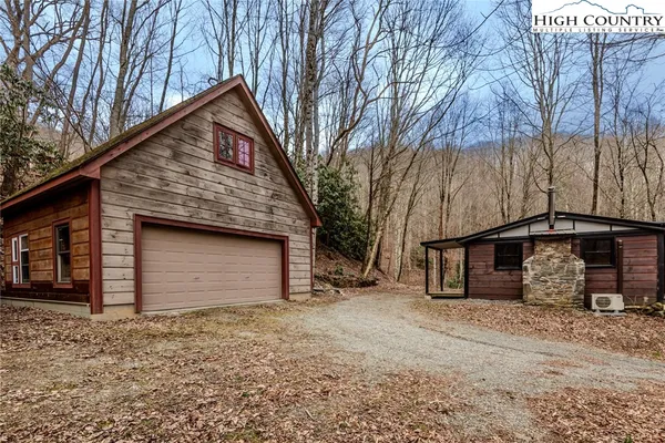 a backyard of a house with large trees and garage