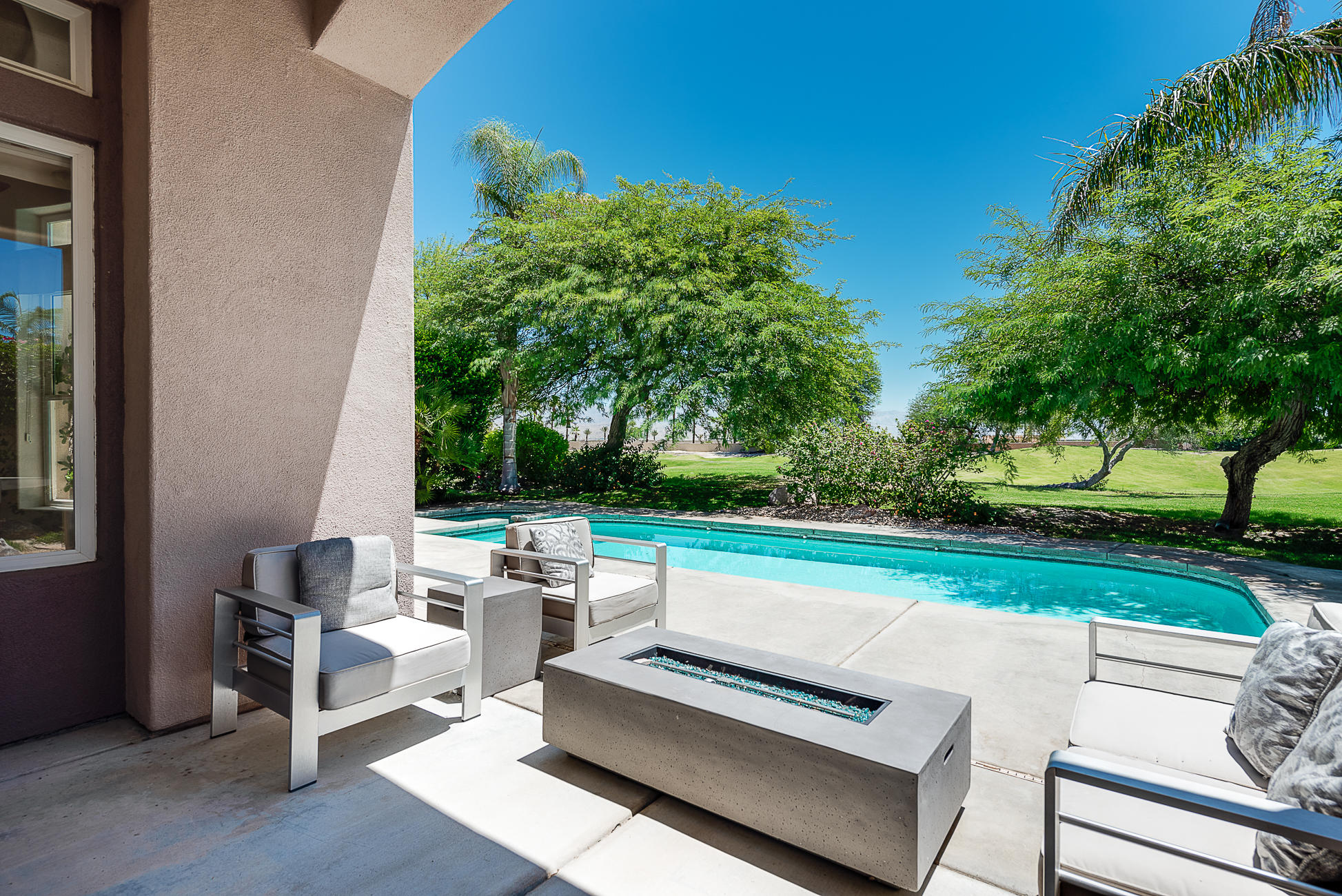 20 Vía Bella Rancho Mirage, CA 92270 - Photo 1 of 26 a view of a patio with couches and table and chairs with wooden fence and plants