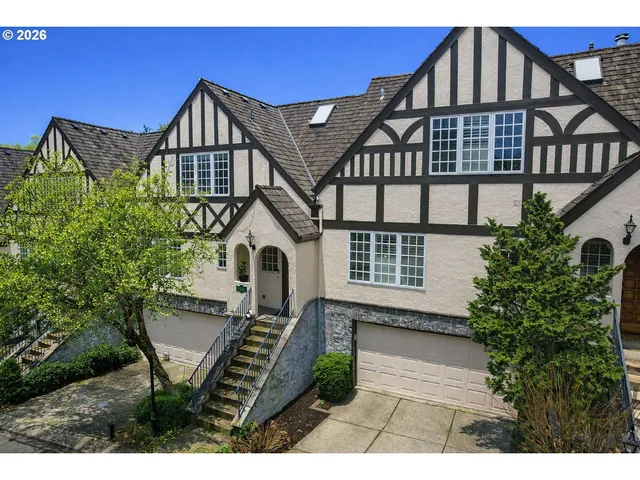 a front view of a house with a yard and potted plants