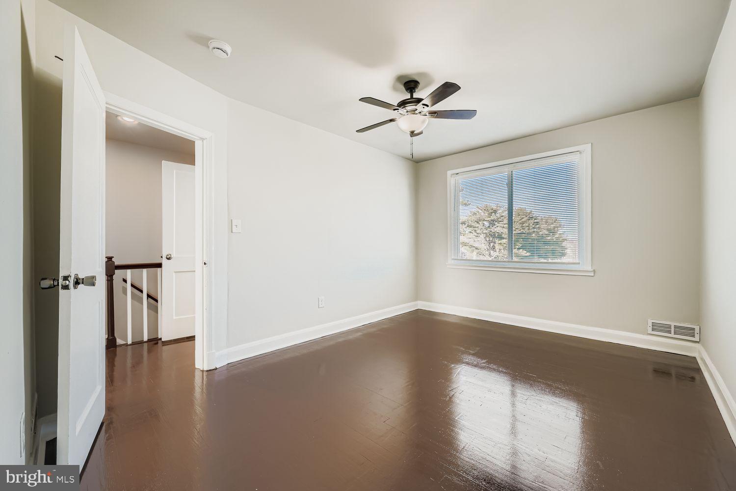 3711 Ina Avenue Baltimore, MD 21206 - Photo 14 of 29 a view of an empty room with a window and wooden floor