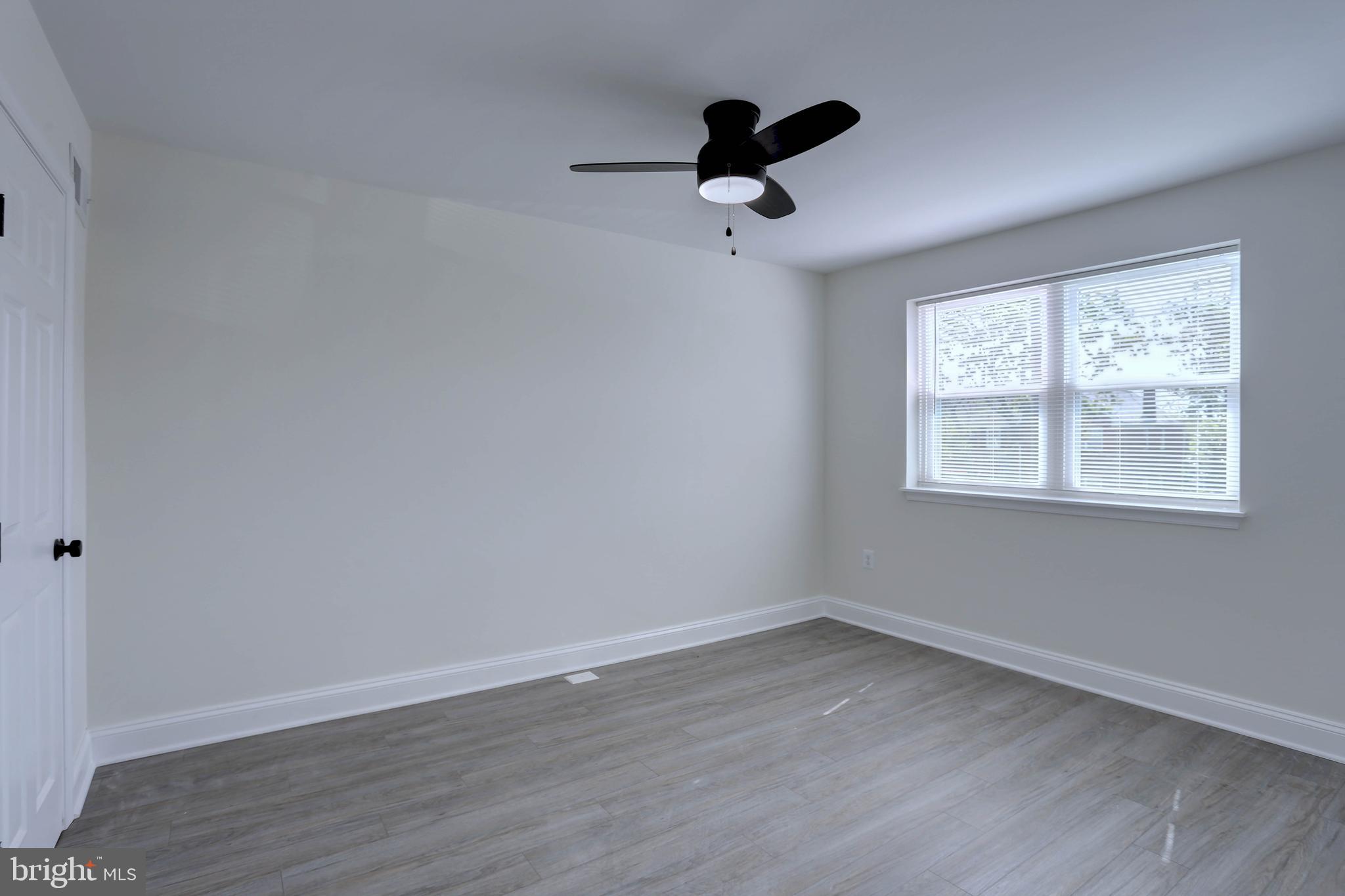 5564 Channing Road Baltimore, MD 21229 - Photo 14 of 32 a view of empty room with wooden floor and fan