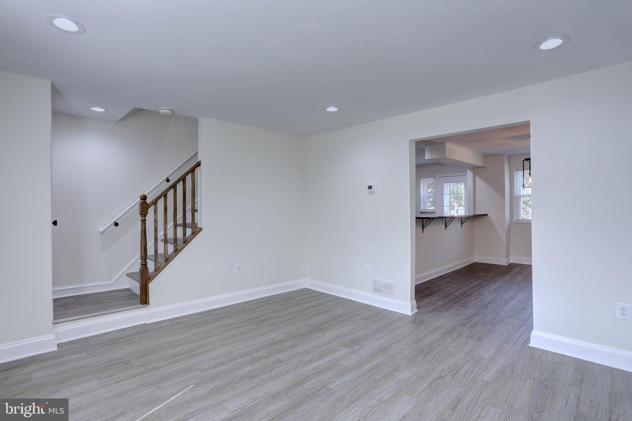 5564 Channing Road Baltimore, MD 21229 - Photo 5 of 32 a view of an empty room with wooden floor and a kitchen