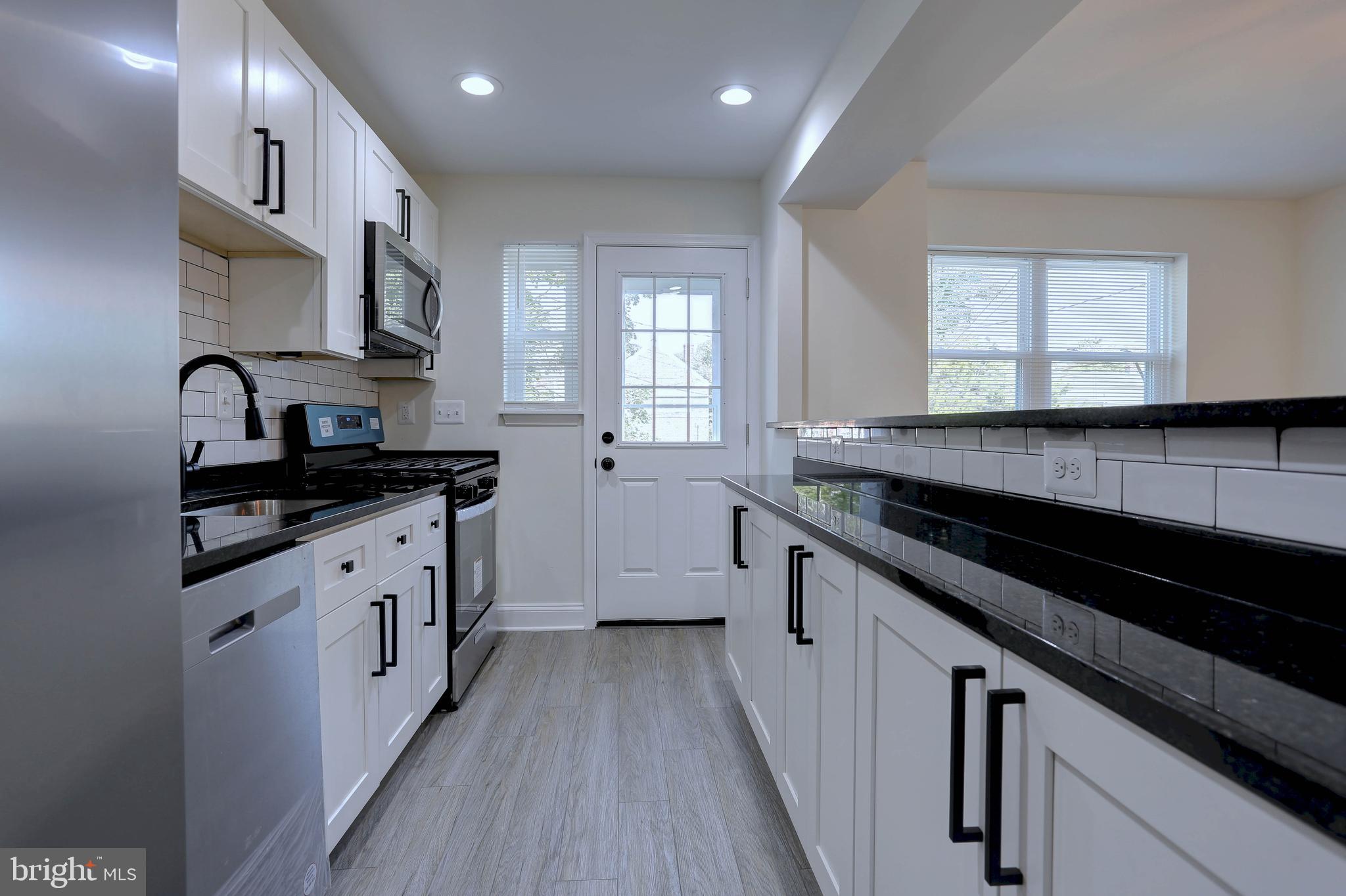 5564 Channing Road Baltimore, MD 21229 - Photo 10 of 32 a kitchen with granite countertop a sink stove and cabinets