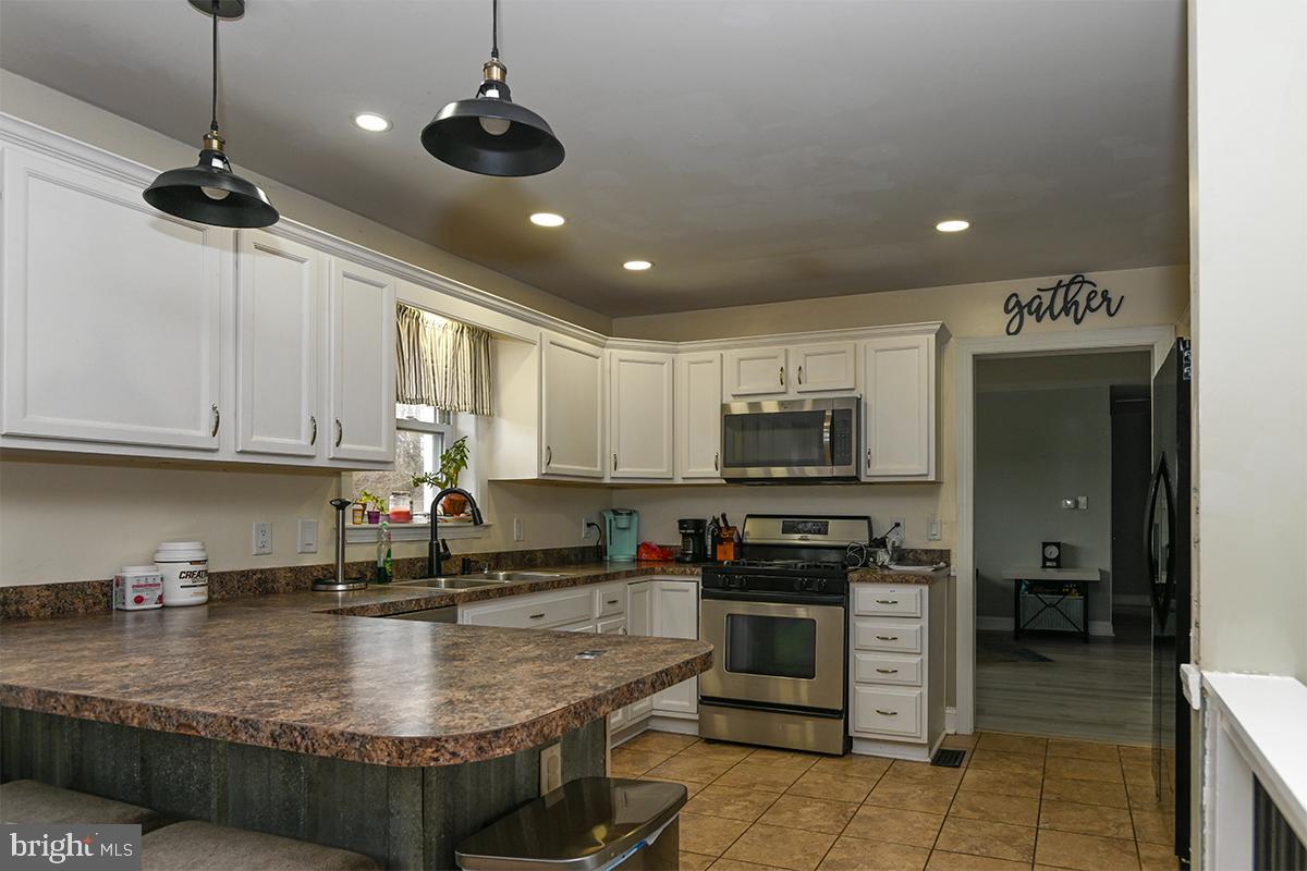 368 Almond Road Pittsgrove, NJ 08318 - Photo 15 of 40 a kitchen with kitchen island granite countertop a sink a counter top space appliances and cabinets