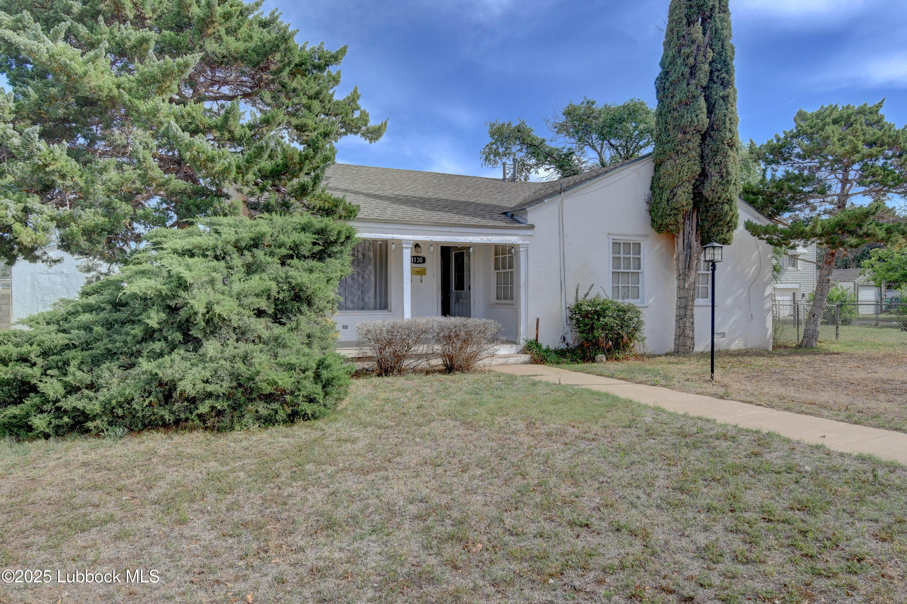 1130 West Garza Street Slaton, TX 79364 - Photo 1 of 16 a view of a house with potted plants and a yard