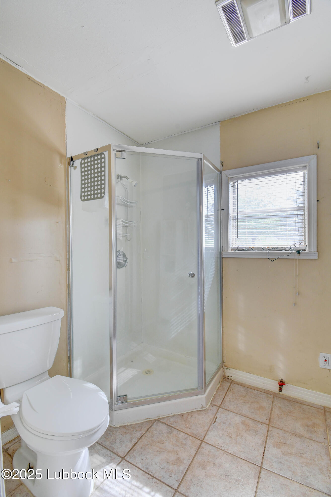 1130 West Garza Street Slaton, TX 79364 - Photo 13 of 16 a bathroom with a toilet and a shower