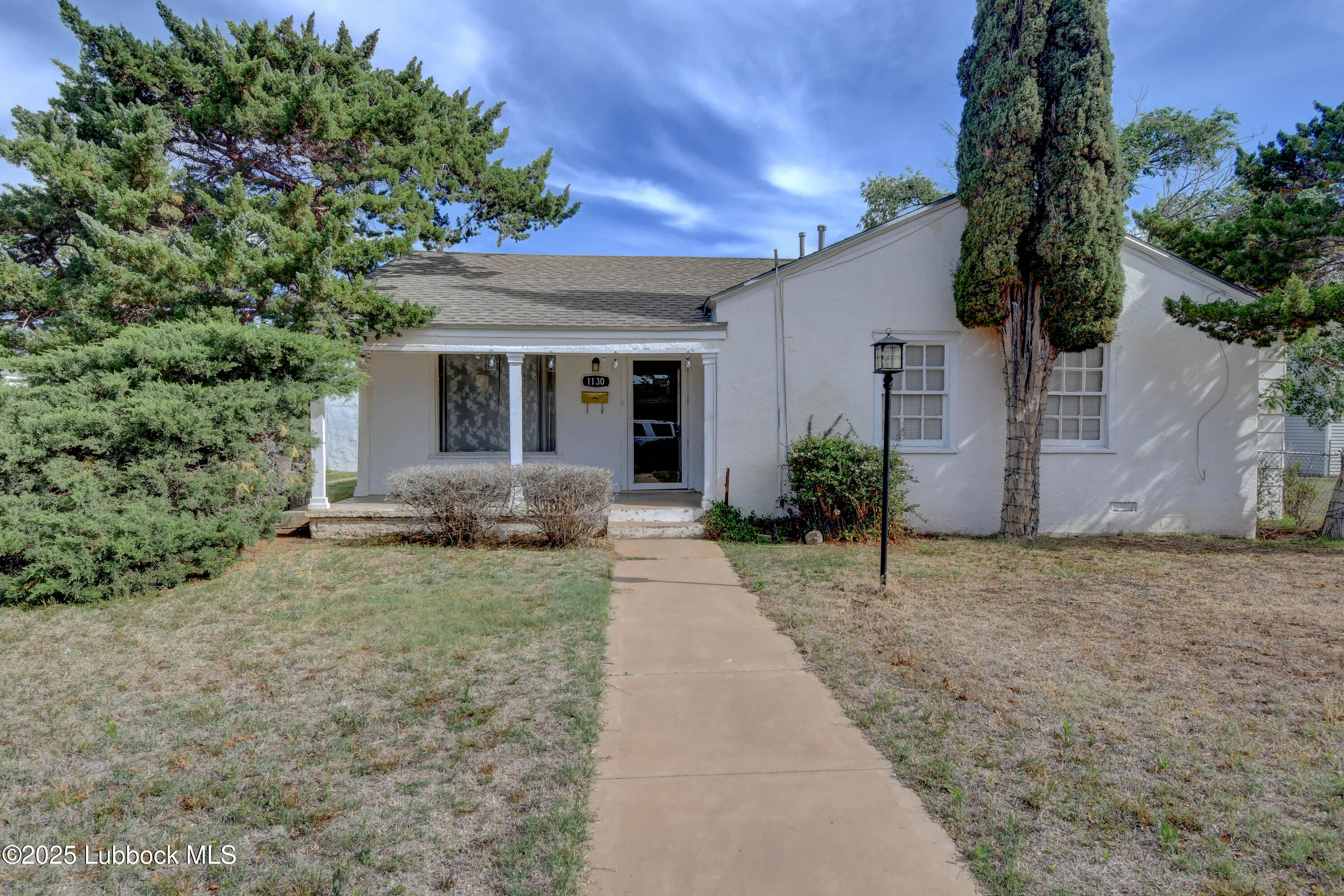 1130 West Garza Street Slaton, TX 79364 - Photo 2 of 16 a front view of a house with garden