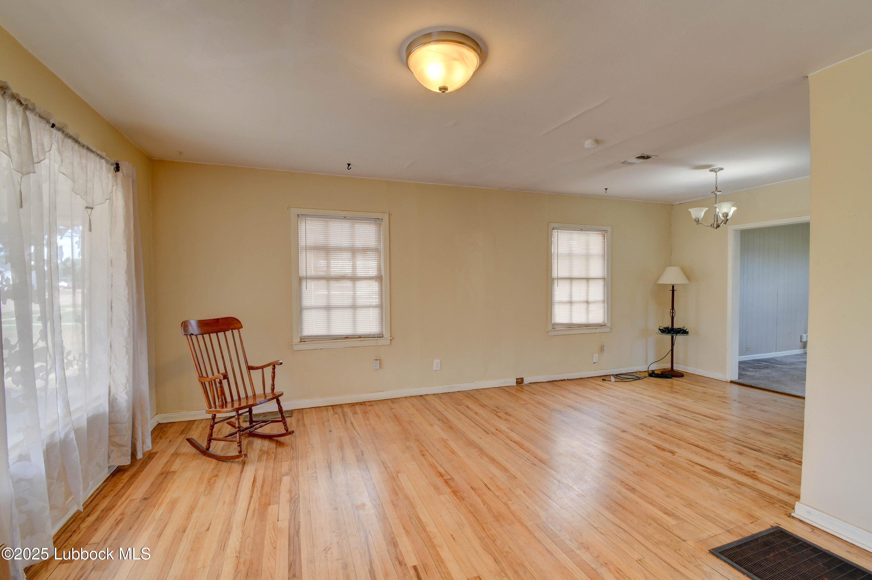 1130 West Garza Street Slaton, TX 79364 - Photo 4 of 16 a view of empty room with wooden floor and fan