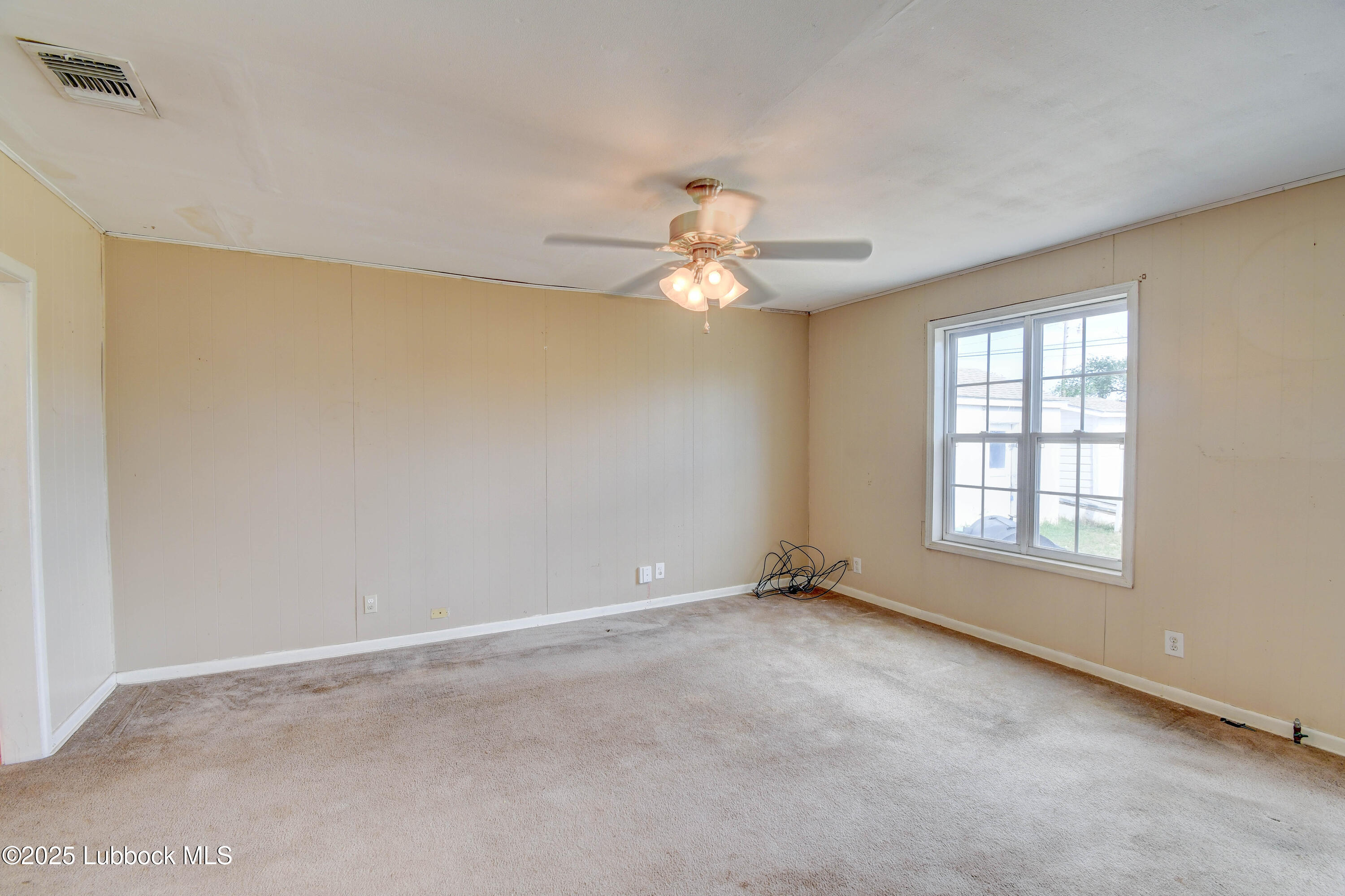 1130 West Garza Street Slaton, TX 79364 - Photo 6 of 16 an empty room with windows and fan