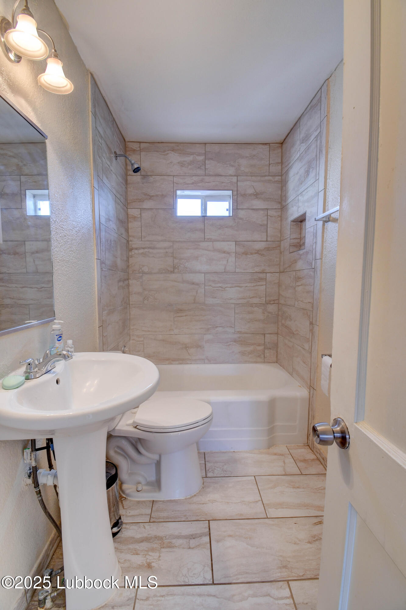 1130 West Garza Street Slaton, TX 79364 - Photo 9 of 16 a bathroom with a sink a toilet and shower