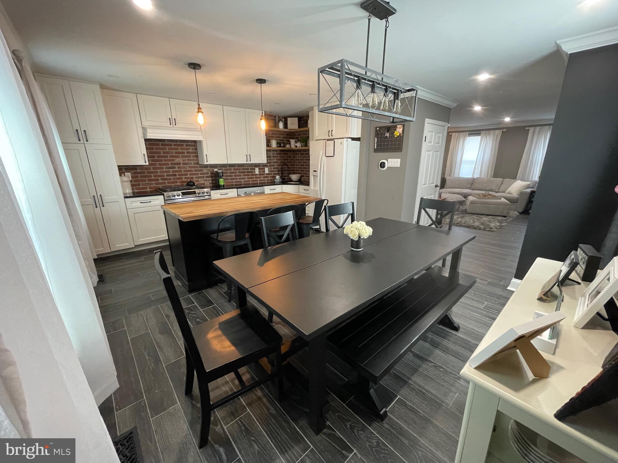 220 Goodford Road Philadelphia, PA 19154 - Photo 9 of 28 a kitchen with a dining table wooden floor and a chandelier