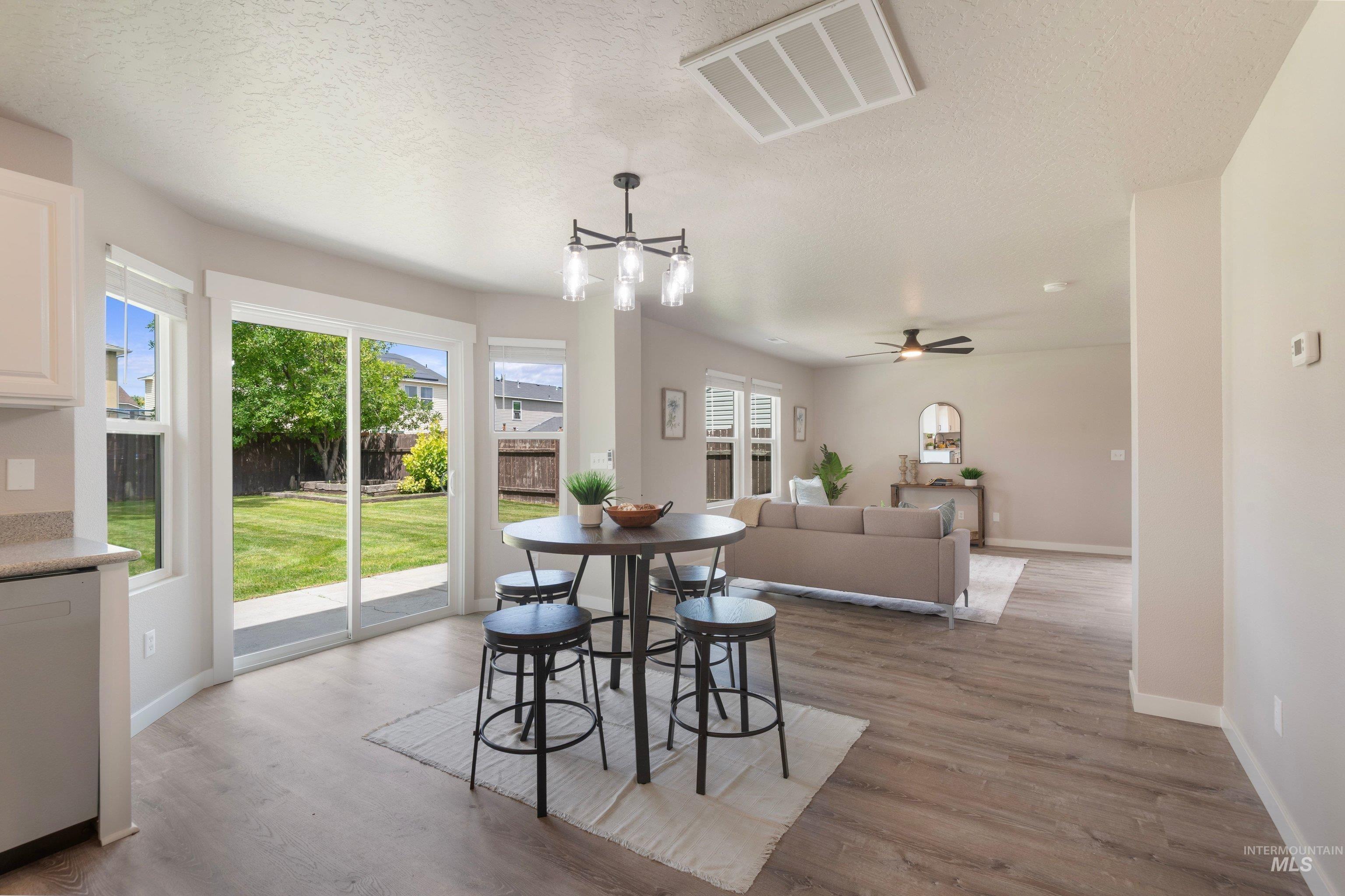 16759 Abram Avenue Caldwell, ID 83607 - Photo 10 of 33 Open-concept living area featuring wood-finish flooring, a contemporary chandelier, and recessed lighting