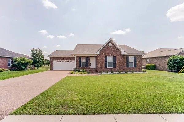 a front view of house with yard and garage