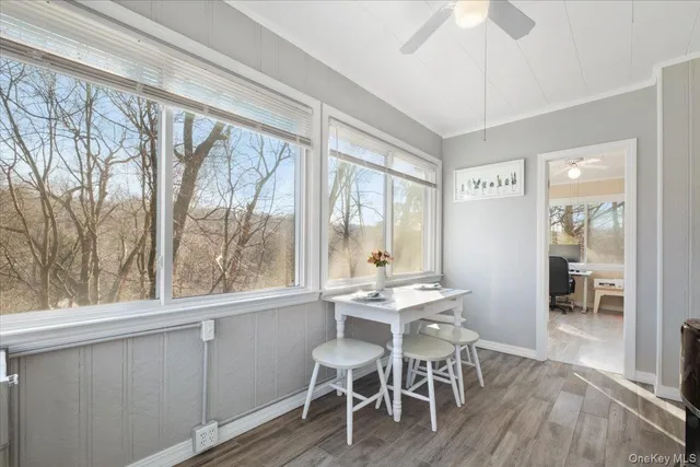 a dining room with wooden floor a chandelier a glass table and chairs
