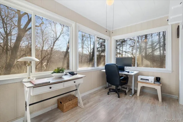 a view of a workspace with furniture and a window