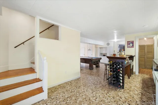 a living room with a couch and a dining table with wooden floor