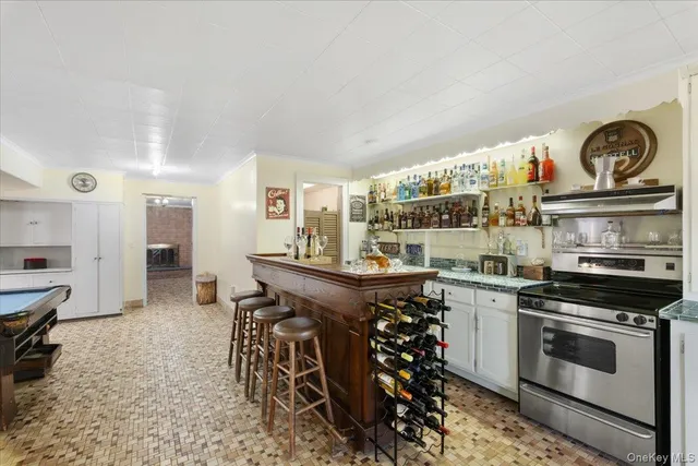 a kitchen with stainless steel appliances a stove a sink cabinets and a dining table