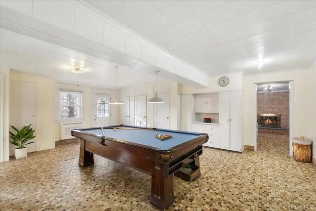 a room with pool table and windows