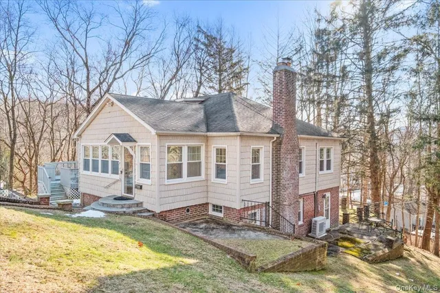a front view of a house with a yard covered with snow and trees