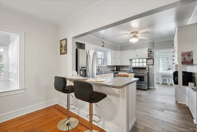 a kitchen with stainless steel appliances kitchen island granite countertop a stove and a refrigerator