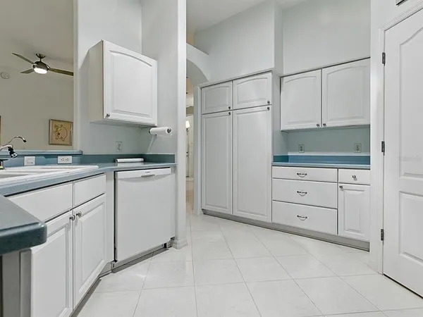 a kitchen with white cabinets and white appliances