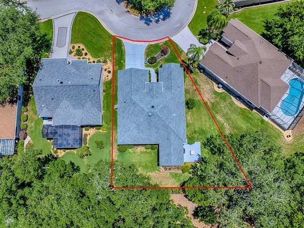 an aerial view of residential houses with outdoor space and trees