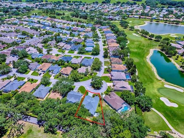 an aerial view of residential houses with outdoor space and trees