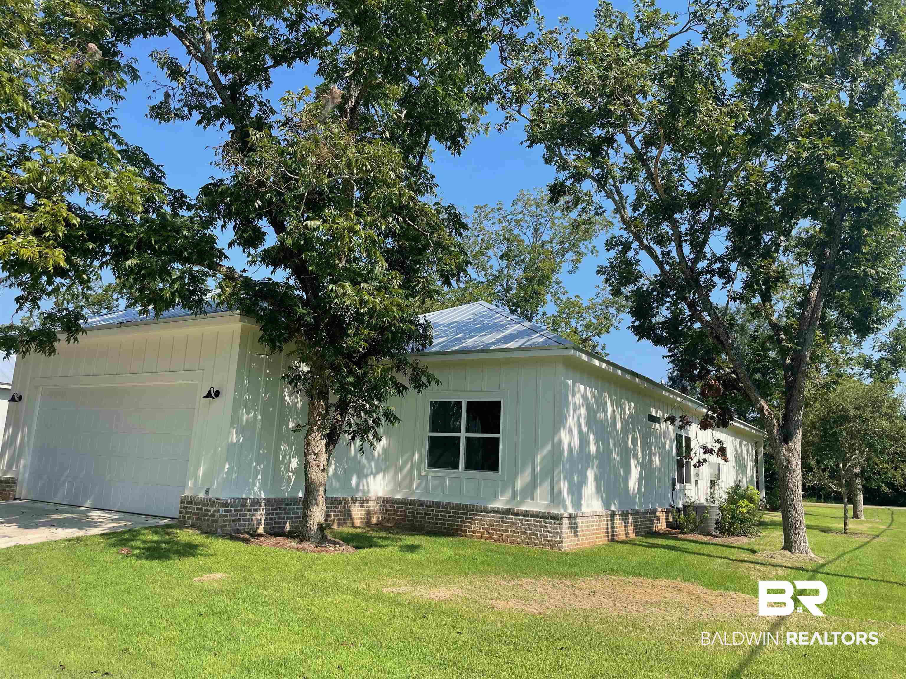 14710 Camelia Street Magnolia Springs, AL 36555 - Photo 16 of 23 View of property exterior featuring a lawn, cooling unit, and a garage