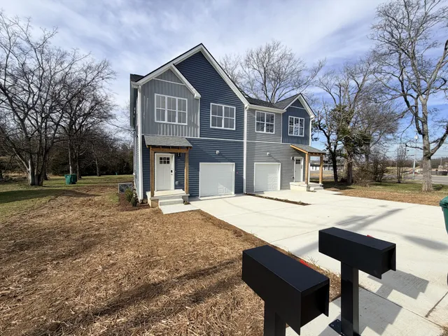 a front view of a house with yard and trees