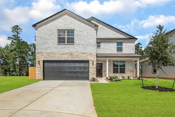 a front view of a house with a yard and garage