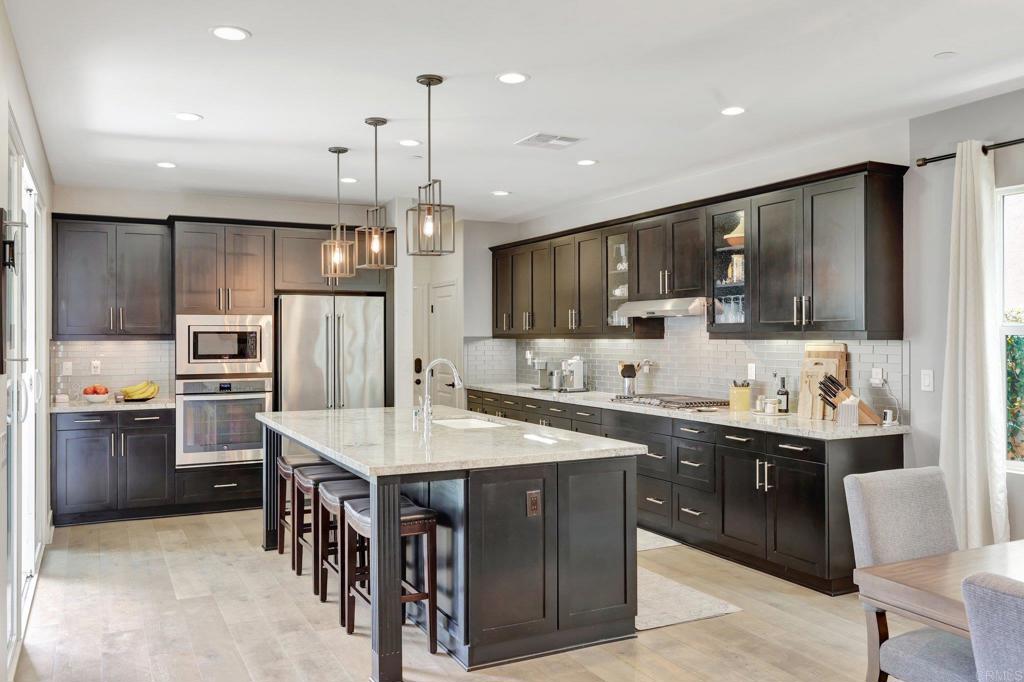 2954 Fledgling Drive Escondido, CA 92029 - Photo 11 of 49 a kitchen with stainless steel appliances granite countertop a sink refrigerator and cabinets