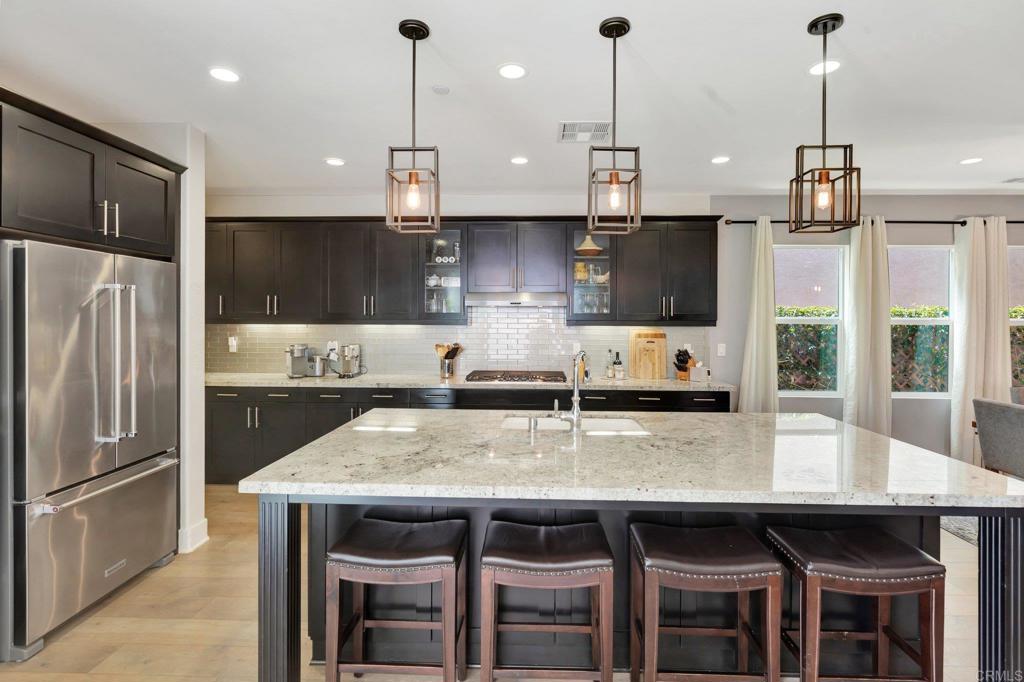 2954 Fledgling Drive Escondido, CA 92029 - Photo 13 of 49 a kitchen with stainless steel appliances granite countertop a stove a refrigerator a kitchen island a table and chairs