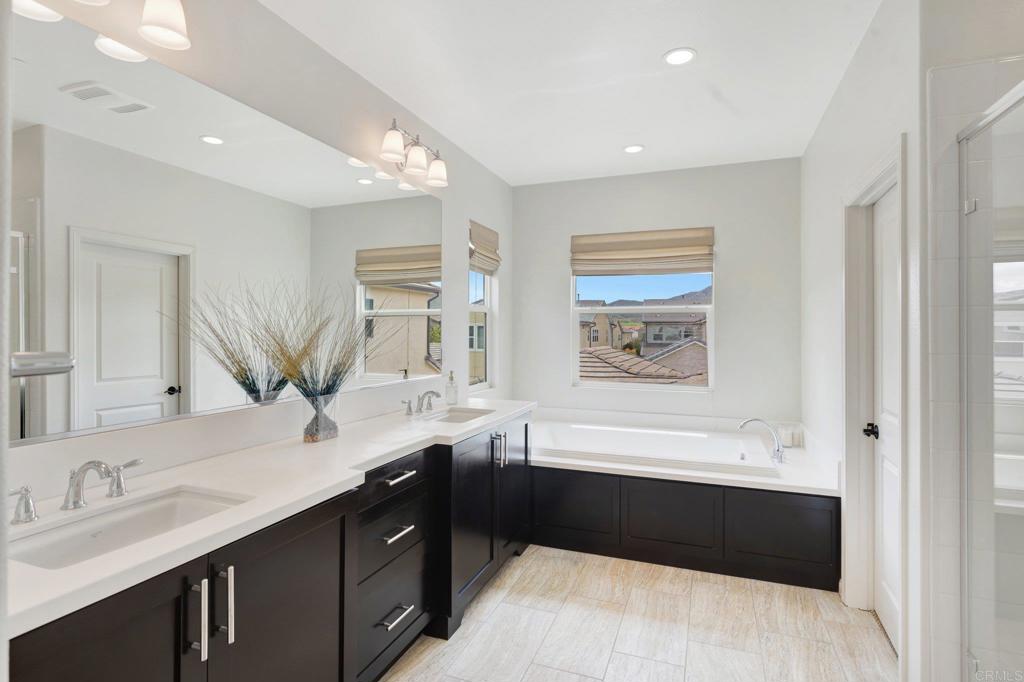 2954 Fledgling Drive Escondido, CA 92029 - Photo 23 of 49 a bathroom with a bathtub double sink and mirror