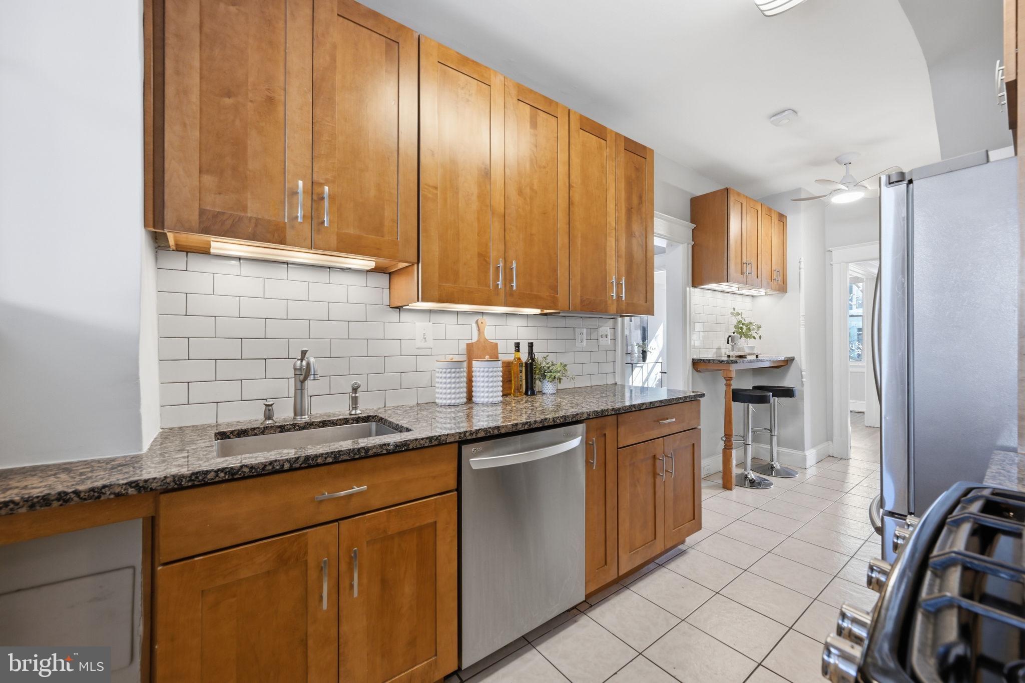 443 Kenyon Street Northwest Washington, DC 20010 - Photo 11 of 30 a kitchen with stainless steel appliances granite countertop a sink stove and refrigerator